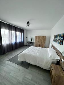 Un dormitorio con una gran cama blanca y una mesa en Sunset Street - La residenza del centro en Arborea 