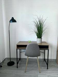 un escritorio con una silla y una planta en Sunset Street - La residenza del centro en Arborea 
