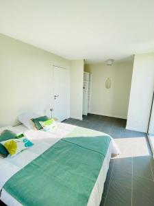 una camera da letto con un grande letto con una coperta verde di House for 4 persons 10 minutes from Paimpol. a Plourivo