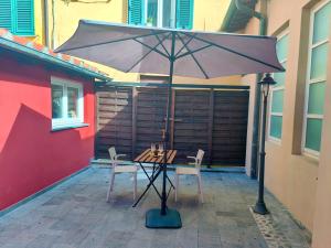 una mesa y sillas bajo una sombrilla en un patio en Cortile in centro - Charm Suite Heart of Lucca, en Lucca