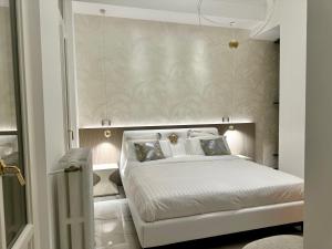1 dormitorio con cama blanca y pared en Gmaison, en Milán