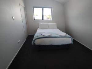 um pequeno quarto com uma cama e uma janela em 117 Leith St em Dunedin