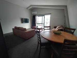 uma sala de estar com uma mesa e um sofá em 117 Leith St em Dunedin
