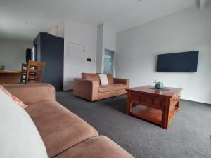 uma sala de estar com dois sofás e uma mesa de centro em 117 Leith St em Dunedin