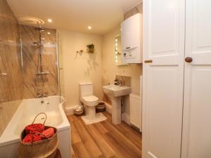 een badkamer met een bad, een toilet en een wastafel bij Shippon Cottage in Castleton +25 foto's