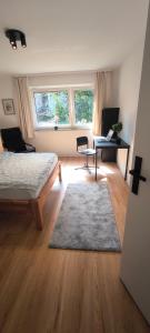 a bedroom with a bed and a desk and a chair at Fresh renovated. 3 Róoms. Central Leonberg. Private parking spot. in Leonberg