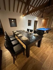 a dining table with chairs and a ping pong ball at Roe Hollow in Old Hurst