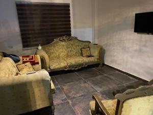 un soggiorno con divano e finestra di شالية ومزرعة ضوء القمر a Umm el ‘Amad