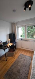 a living room with a desk and a window at Fresh renovated. 3 Róoms. Central Leonberg. Private parking spot. in Leonberg