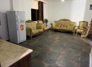 un soggiorno con divani e frigorifero di شالية ومزرعة ضوء القمر a Umm el ‘Amad