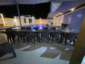 un lungo tavolo e sedie in una stanza di notte di شالية ومزرعة ضوء القمر a Umm el ‘Amad