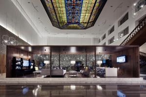 蒙特雷的住宿－Wyndham Monterrey Ambassador Centro，大堂设有大型彩色玻璃天花板和客厅。