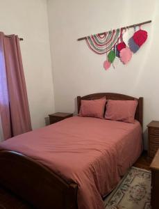 1 dormitorio con 1 cama con sábanas rojas y almohadas rosas en Quintinha do Rio, en Treixedo