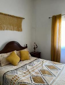 1 dormitorio con cama con edredón y almohadas en Quintinha do Rio, en Treixedo