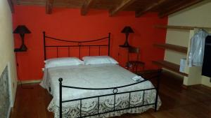 una camera da letto con un letto con una parete rossa di Agriturismo Pietro Falcone a Celico