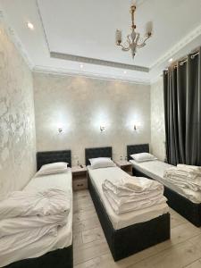 1 dormitorio con 2 camas y lámpara de araña en MIRKA HOTEL LUX, en Samarkand