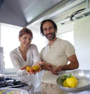 un hombre y una mujer de pie en una cocina sosteniendo fruta en Agrirelais La Bolla, en Agliè