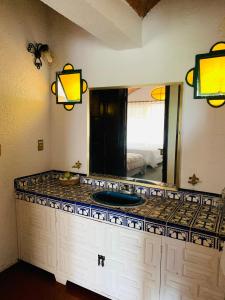 um balcão de casa de banho com um espelho e um lavatório em LA ERMITA "Antigua casa de Cantinflas" em San Miguel de Allende