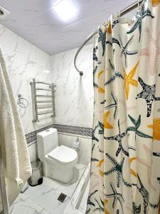 La salle de bains est pourvue de toilettes et d'un rideau de douche. dans l'établissement MIRKA HOTEL LUX, à Samarcande