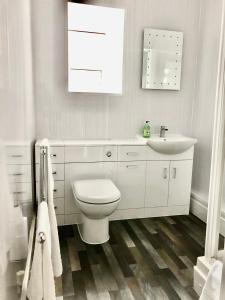 a white bathroom with a toilet and a sink at Clydfan in Holyhead +34 photos
