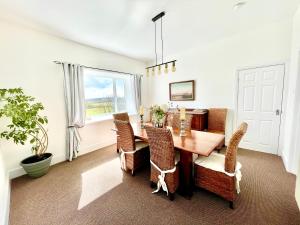 a dining room with a wooden table and chairs at Clydfan in Holyhead