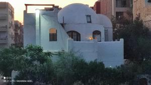 uma casa branca no meio de uma cidade em The Green House em Hurghada