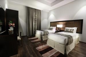 Cette chambre comprend deux lits et une télévision. dans l'établissement Duset Hotel Suites, à Riyad
