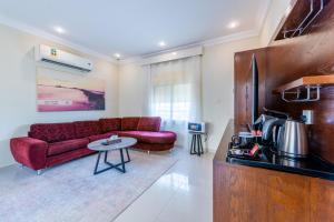 ein Wohnzimmer mit einem roten Sofa und einem Tisch in der Unterkunft منتجع الوفاء درة العروس للعائلات فقط in Durrat Al-Arus