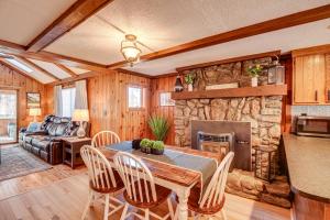 a dining room with a table and a stone fireplace at Inviting Alton Bay Home Near Lake Winnipesaukee! in Alton Bay