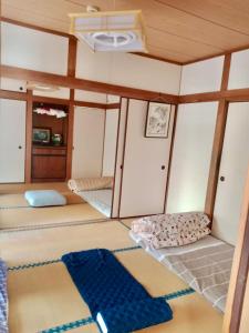 a room with three bunk beds and a ceiling at Shimahama Premium in Miyazaki
