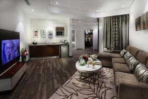 a living room with a couch and a tv at Duset Suites in Riyadh