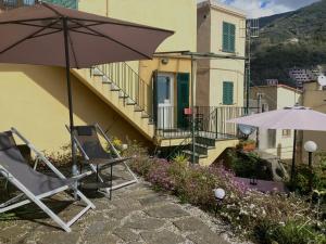a pair of chairs and an umbrella on a patio at Pae veciu casa vacanze in Monterosso al Mare