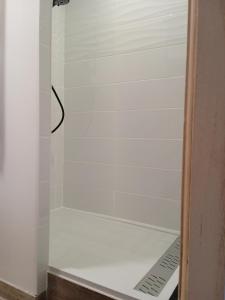 a shower in a bathroom with a white tile wall at Coin Tendresse in Cézac +4 photos