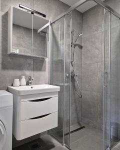 a bathroom with a sink and a glass shower at Apartman Nocturno Trebinje in Trebinje