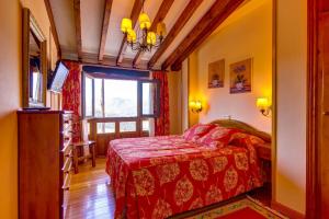 a bedroom with a red bed and a window at Casa Lamadrid in Cahecho