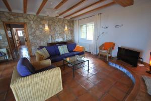sala de estar con sofá azul y TV en Villa Clara, en Denia