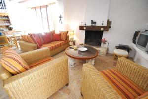 sala de estar con sofás, mesa y chimenea en Villa Condesa en Pedramala