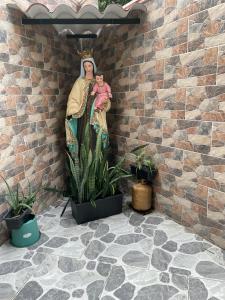 una estatua de una mujer sosteniendo un bebé junto a una pared en HOTEL PALMA ROJA, en Granada