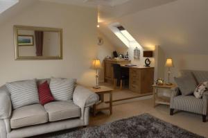 a living room with a couch and a kitchen at Penbontbren Luxury Bed and Breakfast in Aberporth