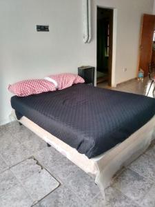 un letto in una camera con materasso nero di LA TRANQUERA DPTOs a Río Cuarto