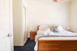 a bedroom with a bed with a dresser and a mirror at Charming Cottage, 7 mins walk to the beach and golf! in Torquay