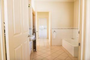 a bathroom with a tub and a sink and a bath tub at Charming Cottage, 7 mins walk to the beach and golf! in Torquay +20 photos
