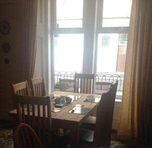 a dining room table with chairs and a large window at Tanglin Guest House in Oban