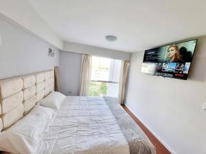 a bedroom with a large bed and a flat screen tv at Departamento Amplio y Centrico en Arequipa in Arequipa