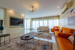 a living room with a couch and a tv at منتجع الوفاء درة العروس للعائلات فقط in Durat  Alarous