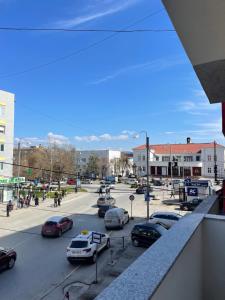 una concurrida calle de la ciudad con coches aparcados en la carretera en Center apartment, en Gnjilane