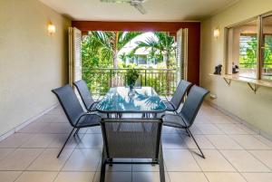 Postcard Perfect - Cairns Nine Pool Tropical Oasis في Westcourt: غرفة طعام مع طاولة وكراسي ونافذة