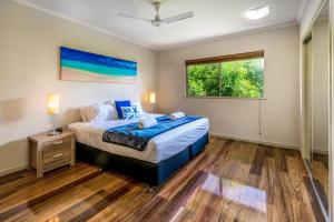 Postcard Perfect - Cairns Nine Pool Tropical Oasis في Westcourt: غرفة نوم بسرير ونافذة
