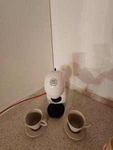 a coffee maker with two cups on the floor at The view Lake ,Appartamento Blevio Fronte lago Como in Blevio