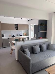 a living room with a couch and a kitchen at Patras Blue Sea and Sky Deluxe Apartment in Patra